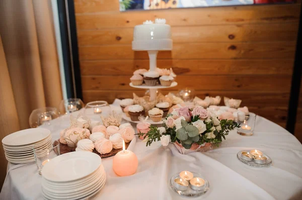 Mesa festiva cubierta con mantel blanco, decorada con velas y composición floral —  Fotos de Stock