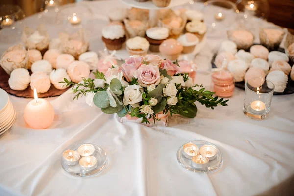 Schöne Blumenkomposition und Kerzen schmücken einen festlichen Tisch, serviert mit Kuchen — Stockfoto