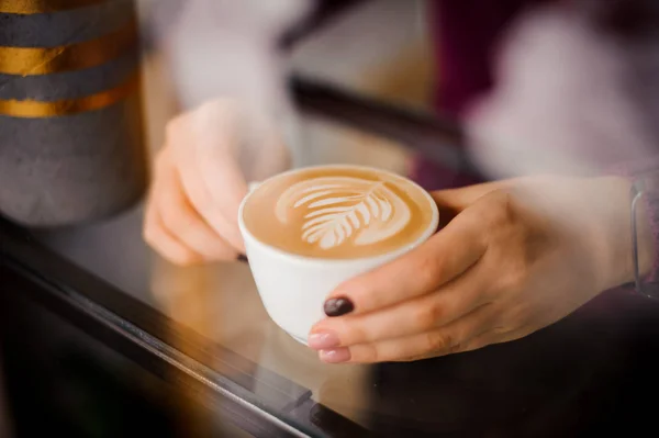 Erkek bir fincan kahve latte sanat ile pencere dışında tutan eller — Stok fotoğraf