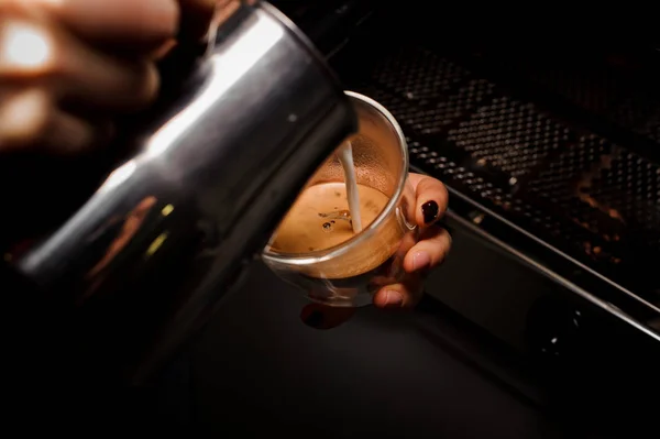 Kvinna händer hälla mjölk från pitcher i kaffekoppen — Stockfoto