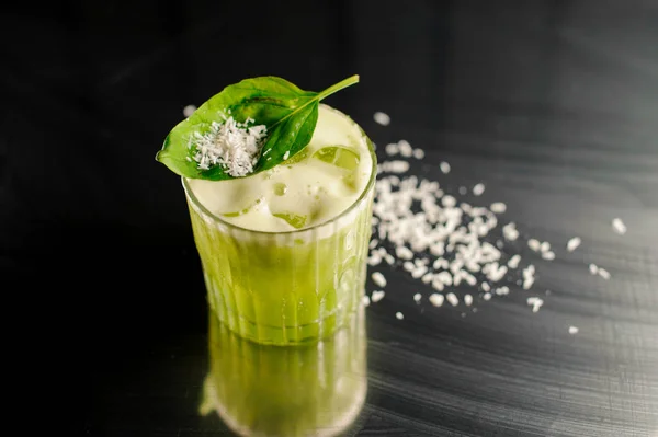 Стакан свежего и здорового зеленого коктейля, украшенный базиликом — стоковое фото