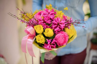 Holding bir güzel parlak pembe ve sarı buket çiçek çiçekçi