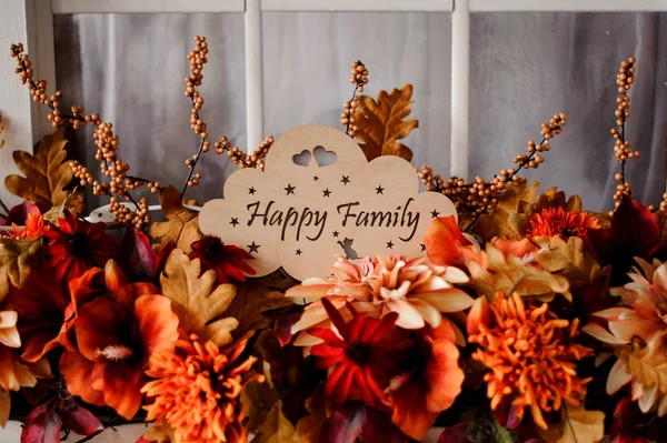 Wooden plaque with the inscription happy family among flowers — Stock Photo, Image