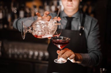 Kırmızı alkollü kokteyl cam içine dökme barmen