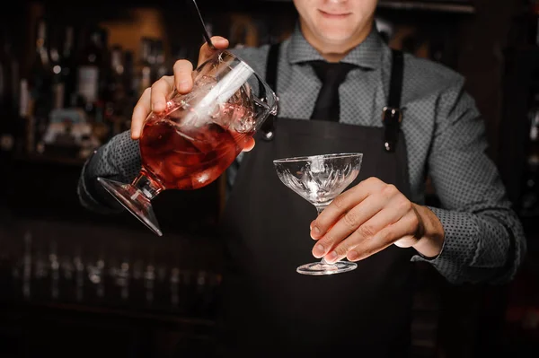 Kırmızı alkollü kokteyl bardak tutan barmen — Stok fotoğraf
