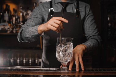 Barmen buz küpleri ile kaşık yardımıyla karıştırarak önlük