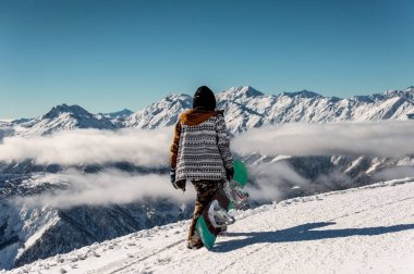 Arkadan görünüşü Dağları arka plan üzerinde duran snowboarder