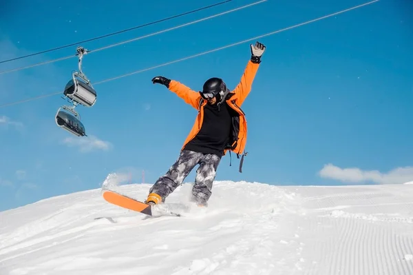 Junger männlicher Snowboarder in bunter Sportbekleidung mit Snowboard unterwegs — Stockfoto