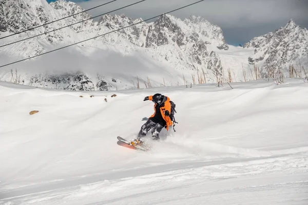 Snowboarder em colorido sportswear equitação no monte de neve — Fotografia de Stock