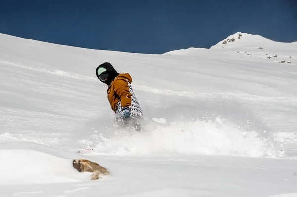 산 경사면 아래로 타고 운동복의 snowboarder — 스톡 사진