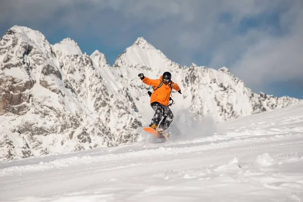 Snowboarder ativo montando na encosta da montanha — Fotografia de Stock