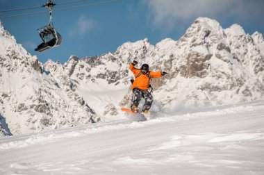 Erkek snowboard dağ yamacında atlama