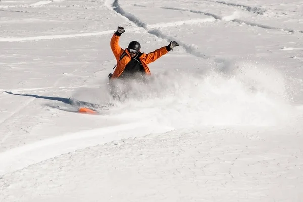 Snowboarder em sportswear laranja montando na encosta da neve — Fotografia de Stock