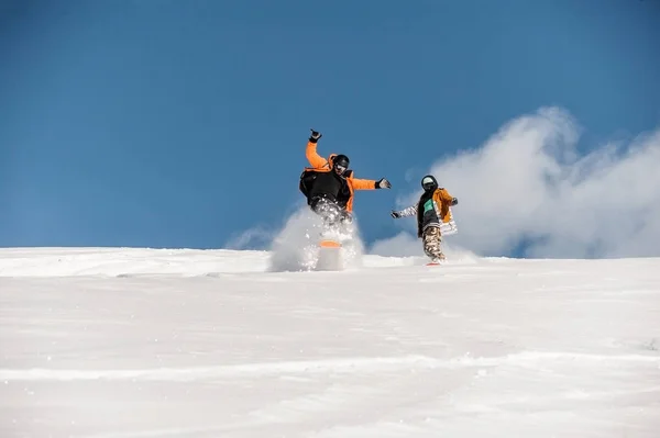 Ζευγάρι των snowboarders σε αθλητικά είδη ιππασίας στην πλαγιά του βουνού σε σκόνη — Φωτογραφία Αρχείου