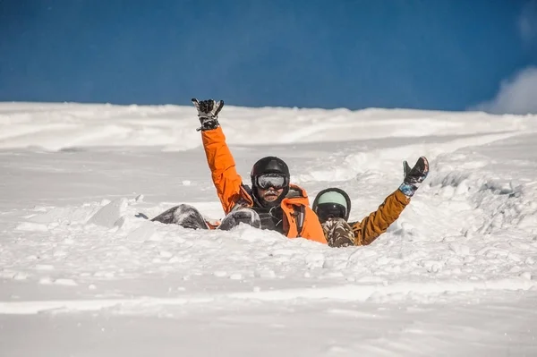 Pár hó snowboardosok integetett a kezek lejtő csökkent — Stock Fotó