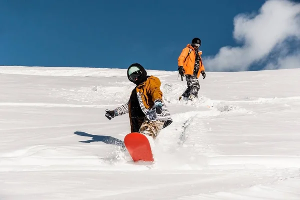 Dois snowboarders no sportswear que monta abaixo da inclinação da montanha — Fotografia de Stock