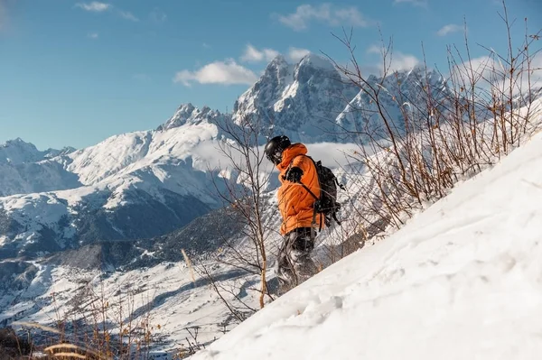 男性滑雪在橙色运动服骑马下山的山坡 — 图库照片