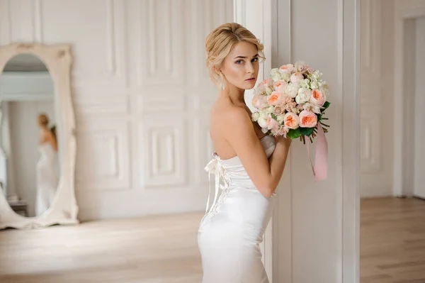 Bella sposa bionda nell'elegante abito bianco con un bouquet da sposa — Foto Stock