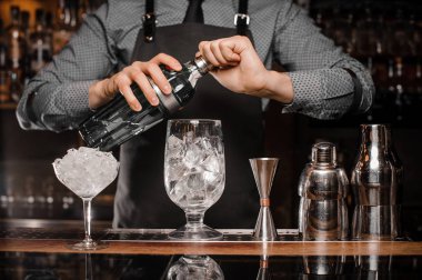 Barmen bir kokteyl bar ekipmanları yardımı ile yapma önlük