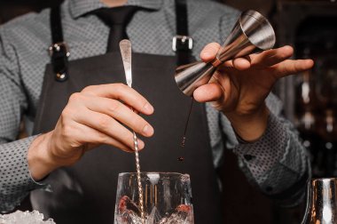 Barmen bir gömlek, kravat ve alkollü bir içki yapım önlük