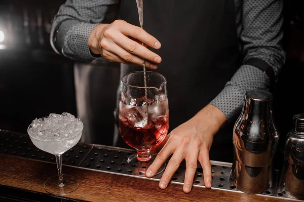 Barmen s el alkollü bir kokteyl ile buz karıştırma
