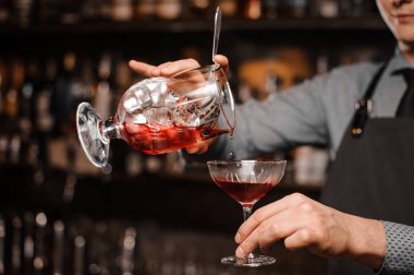 Barmans el bir alkollü içki kokteyl cam içine dökme