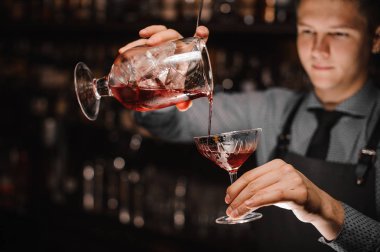 Genç barmen taze alkollü kokteyl kokteyl bardağına dökme