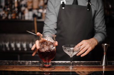 Genç barmen taze bir alkollü kokteyl bardağına kokteyl yapmak
