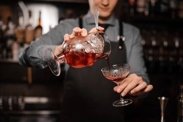 Barman derramando uma bebida alcoólica fresca na taça de coquetel — Fotografia de Stock