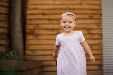 Tatlı gülümseyen küçük kız şirin pembe elbise giymiş