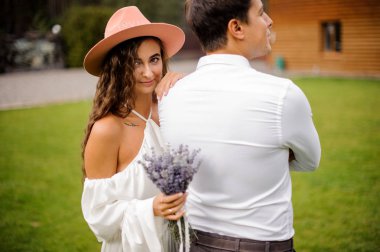 Beyaz gömlek ve lavanta kokulu beyaz elbiseli kıvırcık gelin gülümseyen damat