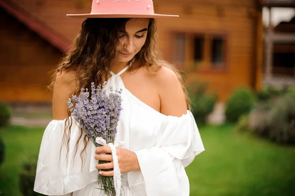 Bella donna riccia vestita in abito bianco con bouquet di lavanda — Foto Stock
