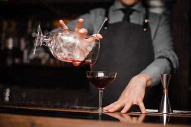 Barmen bir kravat ve kırmızı alkollü içecek bir kokteyl cam dökme önlük