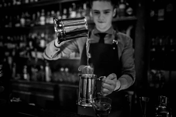 Black and white photo of bartender making cocktail