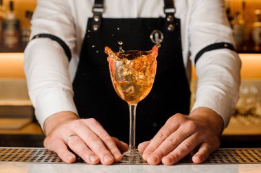 Alkollü içki sıçramasına ile bir cam holding Barmans eller