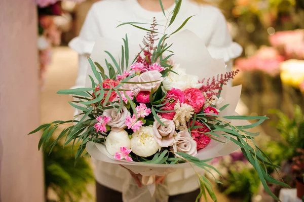 Mujer vestida con un suéter blanco sosteniendo un brillante y hermoso ramo de San Valentín — Foto de Stock