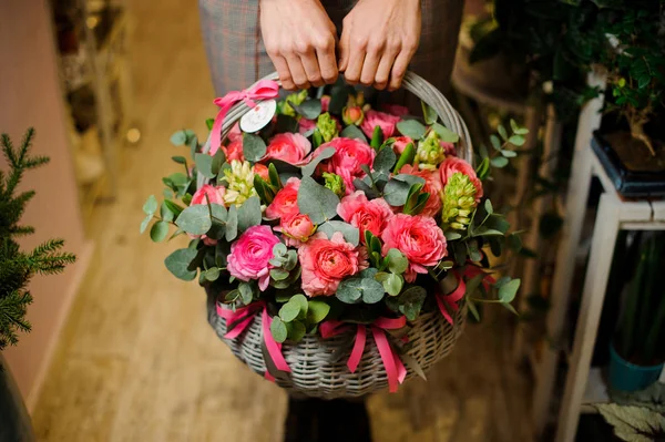 Mãos femininas segurando uma grande cesta de vime com flores para o dia dos namorados — Fotografia de Stock