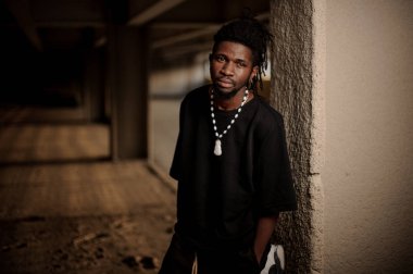 Afro-Amerikan adam duvara yakın duran dreadlocks ile