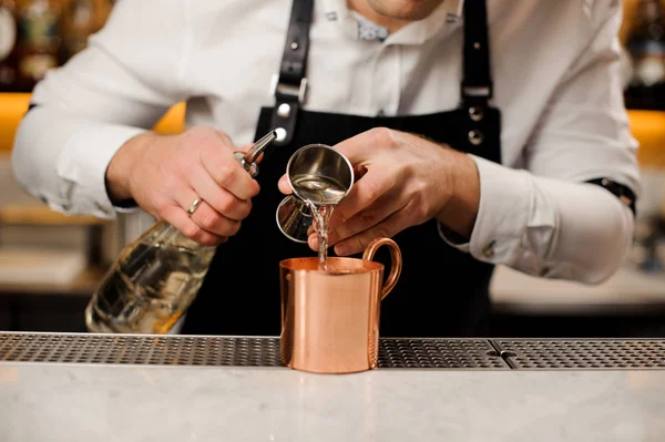 Barman vertiendo una porción de bebida alcohólica en una taza —  Fotos de Stock