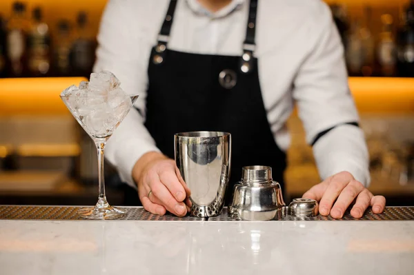 Barman debout près du comptoir du bar avec verre à cocktail et shaker — Photo