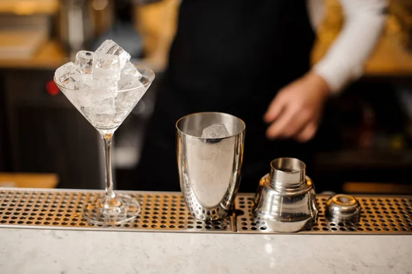 Shaker e bicchiere da cocktail riempito con cubetti di ghiaccio sul bancone del bar — Foto Stock