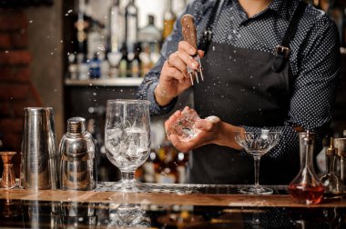 Buz bir kokteyl yapmak için büyük bir parçası kırma barmen