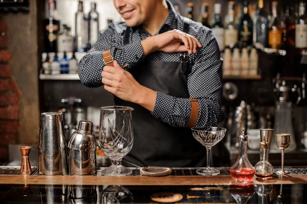 Barman sorrindo de pé atrás do balcão de bar com um equipamento de bar — Fotografia de Stock