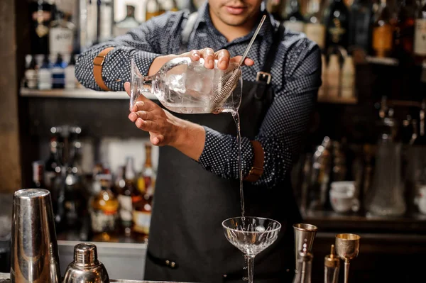 Barman derramando bebida alcoólica fria em um copo de coquetel — Fotografia de Stock