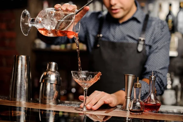 Barman adicionando bebida alcoólica vermelha no copo de coquetel — Fotografia de Stock