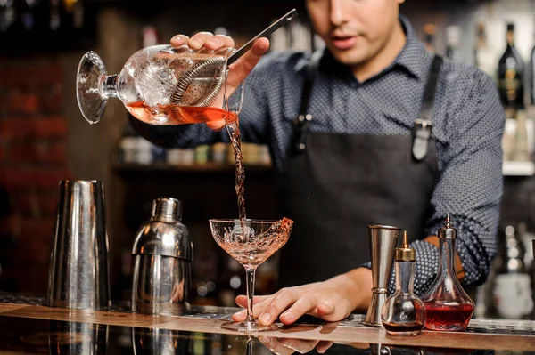 Barkeeper fügt rotes alkoholisches Getränk in Cocktailglas hinzu — Stockfoto