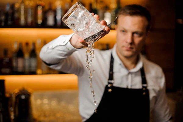 Barmann gießt Wasser aus einem Glas mit Eiswürfeln — Stockfoto