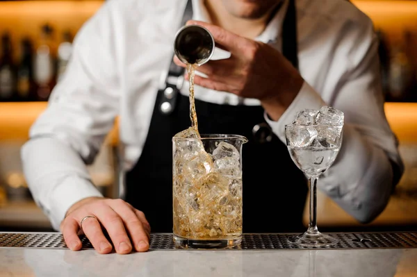 Barman mano verter una porción de bebida alcohólica en un vaso — Foto de Stock