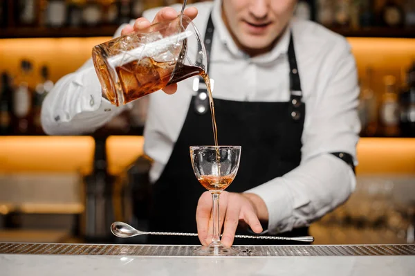 Barman alcoholische drank in een glas gieten — Stockfoto