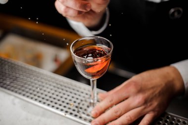 Bir bardak portakal dilim ile alkollü içki ile dolu tutan el mans